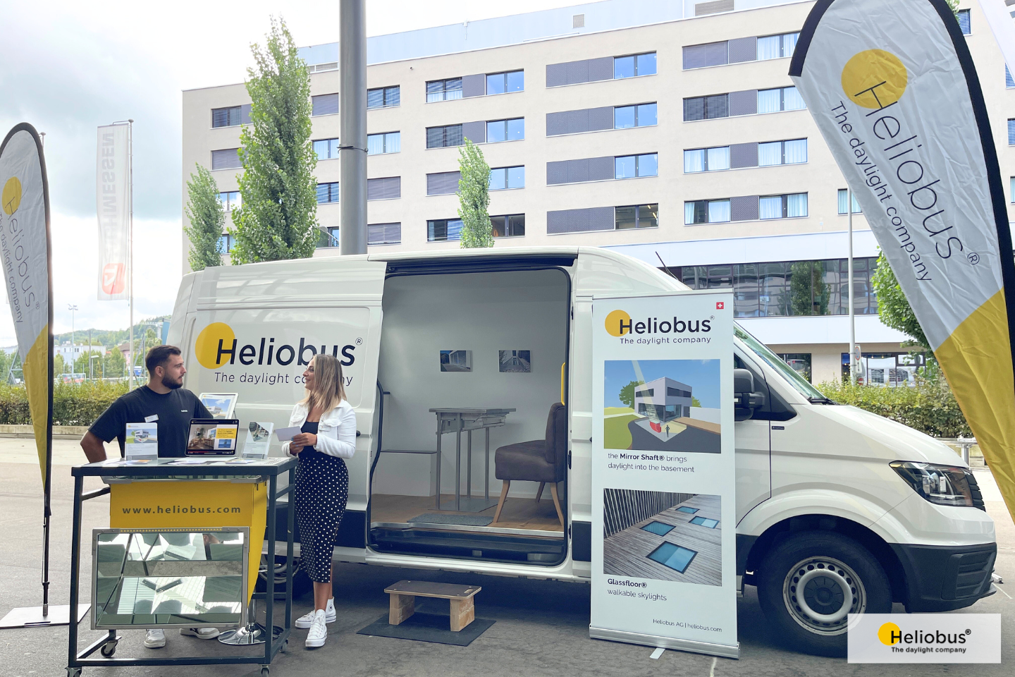 Showmobil der Firma Heliobus steht mit offener Wagentür und zwei Verkäufern auf dem Messegelände der Messen Zürich.